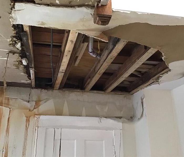 Damaged ceiling from leak with rafters showing